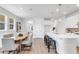 Open-concept kitchen and dining area with white cabinets, sleek countertops, pendant lighting, and hardwood floors at 652 Allora Ave, Nokomis, FL 34275