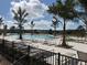 A community pool with rows of lounge chairs and palm trees on a beautiful sunny day at 652 Allora Ave, Nokomis, FL 34275