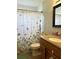 Bathroom with floral shower curtain and wood vanity at 3464 Silverstone Ct, Plant City, FL 33566