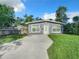 Newly renovated home with light gray exterior, inviting front yard and fresh landscaping at 3128 17Th N St, St Petersburg, FL 33713