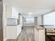 Open concept kitchen with white cabinets, granite counters, and wood-look floors at 3128 17Th N St, St Petersburg, FL 33713