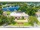 Aerial view of a lakeside home with lush landscaping, dock and solar panels at 3744 E Lake Dr, Land O Lakes, FL 34639