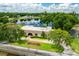 Home showing an aerial view of solar panels, lakeside property, an American flag, and mature trees at 3744 E Lake Dr, Land O Lakes, FL 34639