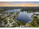 Aerial view captures properties nestled along a scenic lake, many featuring private docks for boating enthusiasts at 3744 E Lake Dr, Land O Lakes, FL 34639