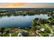 Expansive aerial view of a large lake with boats, surrounded by beautiful homes at sunset at 3744 E Lake Dr, Land O Lakes, FL 34639