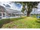 Expansive backyard with covered pool, mature trees, and lake view at 3744 E Lake Dr, Land O Lakes, FL 34639