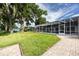 Large backyard with lush lawn, mature trees, screened pool, and lake access at 3744 E Lake Dr, Land O Lakes, FL 34639