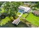 Aerial view of a backyard featuring a screened pool, lush lawn, and private dock at 3744 E Lake Dr, Land O Lakes, FL 34639