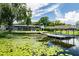 Beautiful backyard view of a screened in lanai, boat dock, and lush lawn near the water at 3744 E Lake Dr, Land O Lakes, FL 34639