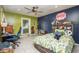 A green and blue bedroom with tile floors, a ceiling fan and a desk at 3744 E Lake Dr, Land O Lakes, FL 34639