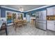 Inviting dining area with stainless steel refrigerator, tile flooring, and serene view of outdoor pool at 3744 E Lake Dr, Land O Lakes, FL 34639