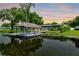 Waterfront property featuring a covered boat dock with a boat, and a screened-in patio at 3744 E Lake Dr, Land O Lakes, FL 34639