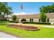 Traditional home with manicured front yard, an American flag, and mature landscaping at 3744 E Lake Dr, Land O Lakes, FL 34639