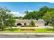 Home with mature trees, a manicured front yard, and an American flag. Located on a lake at 3744 E Lake Dr, Land O Lakes, FL 34639