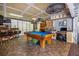 Bright game room featuring a blue felt pool table, a wooden bar with stools, and a work station at 3744 E Lake Dr, Land O Lakes, FL 34639