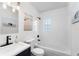 Simple bathroom with white tile, bathtub, and navy vanity at 3214 E Dr Martin Luther King Jr Blvd, Tampa, FL 33610