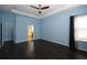 Bedroom with dark wood floors, blue walls, and en-suite bathroom at 4212 Wildstar Cir, Wesley Chapel, FL 33544