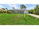 Ranch style home with a gray exterior, a large front yard, and a for sale sign at 455 Lenoir Nw St, Port Charlotte, FL 33948