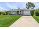 Single story home with gray exterior, attached garage, and well-manicured lawn at 455 Lenoir Nw St, Port Charlotte, FL 33948