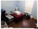 A bedroom with dark wood flooring and a small table at 4605 N 39Th St # 1/2, Tampa, FL 33610