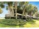 Ground level view of condo with a screened-in patio and tropical landscaping at 636 Yardarm Dr # 636, Apollo Beach, FL 33572