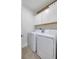Bright laundry room with washer, dryer, and overhead cabinets at 17231 Holly Well Ave, Wimauma, FL 33598