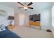 Relaxing bedroom with blue sofa, ceiling fan and media console at 17231 Holly Well Ave, Wimauma, FL 33598