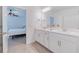 Clean bathroom with double vanity and view of bedroom at 17231 Holly Well Ave, Wimauma, FL 33598