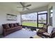 Spacious screened porch overlooking a pond, wicker furniture and ceiling fan at 17231 Holly Well Ave, Wimauma, FL 33598