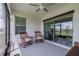 Relaxing screened porch with wicker furniture and view of pond at 17231 Holly Well Ave, Wimauma, FL 33598