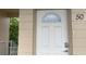 Unit entrance with a white door and a beige building at 2310 Denmark St # 50, Clearwater, FL 33763