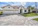 Home with a three-car garage, paver driveway, and landscaped yard at 32884 Estate Garden Dr, Wesley Chapel, FL 33545