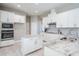 Modern white kitchen featuring granite countertops, stainless appliances, and white shaker cabinets at 32884 Estate Garden Dr, Wesley Chapel, FL 33545