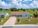 Single-story home with a paved driveway and golf course views at 609 Fox Hills Dr, Sun City Center, FL 33573