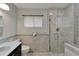 Modern bathroom with glass-enclosed shower, dark vanity, and decorative tiles at 609 Fox Hills Dr, Sun City Center, FL 33573