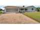 Charming single-story home with a brick exterior, well-manicured lawn, and attached garage at 609 Fox Hills Dr, Sun City Center, FL 33573