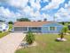 Charming single-story home with a brick exterior, well-manicured lawn, and attached garage at 609 Fox Hills Dr, Sun City Center, FL 33573