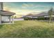 Private backyard with a covered patio, grass lawn, and a white fence at 7134 Heather Sound Loop, Wesley Chapel, FL 33545