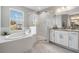 Modern bathroom with a glass shower, soaking tub, and dual vanity at 7134 Heather Sound Loop, Wesley Chapel, FL 33545