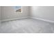 Empty bedroom with gray carpet and large window offering natural light at 7134 Heather Sound Loop, Wesley Chapel, FL 33545