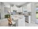 Modern white kitchen featuring stainless steel appliances, large island with seating, and ample counter space at 7134 Heather Sound Loop, Wesley Chapel, FL 33545