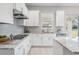 Bright white kitchen with sleek appliances, granite countertops, and plenty of cabinet storage at 7134 Heather Sound Loop, Wesley Chapel, FL 33545