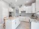 Bright, modern kitchen featuring white cabinets, a large island, and stainless steel appliances at 7134 Heather Sound Loop, Wesley Chapel, FL 33545
