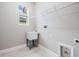 Laundry room with white utility sink, wire shelving, and light wood-look flooring at 7134 Heather Sound Loop, Wesley Chapel, FL 33545