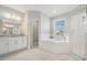 Bright, spacious main bathroom with soaking tub, glass shower, and dual vanity at 7134 Heather Sound Loop, Wesley Chapel, FL 33545