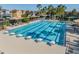 Inviting community pool with lap lanes, a ' area, lounge chairs, and shade umbrellas at 7134 Heather Sound Loop, Wesley Chapel, FL 33545