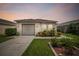 Evening view of a single-story house with a garage and well-maintained landscaping at 6108 Lanshire Dr, Tampa, FL 33634