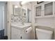 Small bathroom with white vanity, floral wallpaper, and toilet at 6108 Lanshire Dr, Tampa, FL 33634