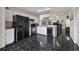 Kitchen with black appliances, white cabinets, and dark-tiled flooring at 6108 Lanshire Dr, Tampa, FL 33634