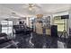 Living room featuring dark leather sofas, tile flooring, and an open floor plan at 6108 Lanshire Dr, Tampa, FL 33634